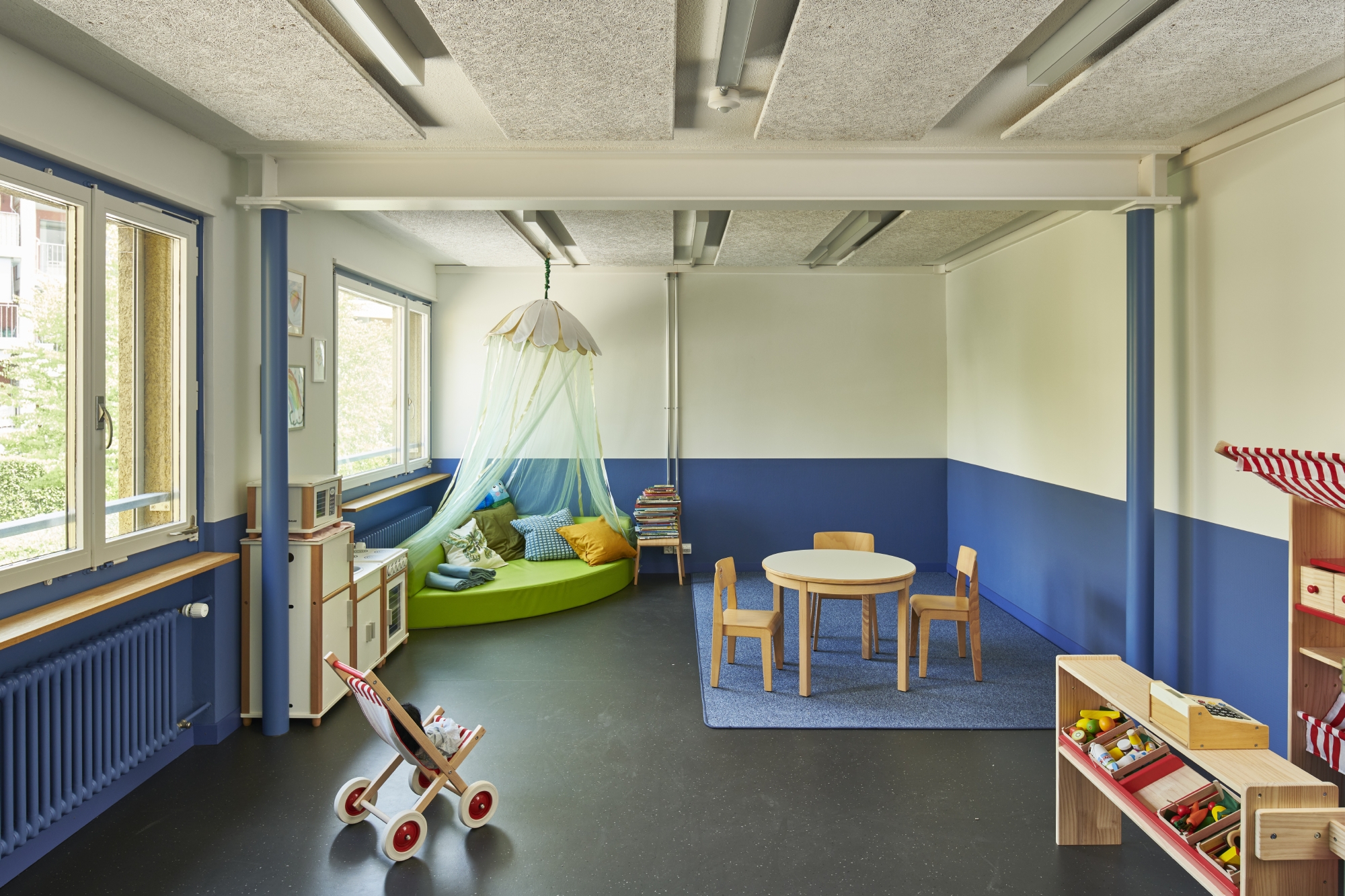 Blick in ein möbliertes Kindergartenzimmer mit wiederverwendeten Stahlträgern (Bild: Theodor Stalder)